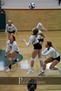 Freshman Taryn Roberts goes up to hit a ball against ACC while several teammates cover.