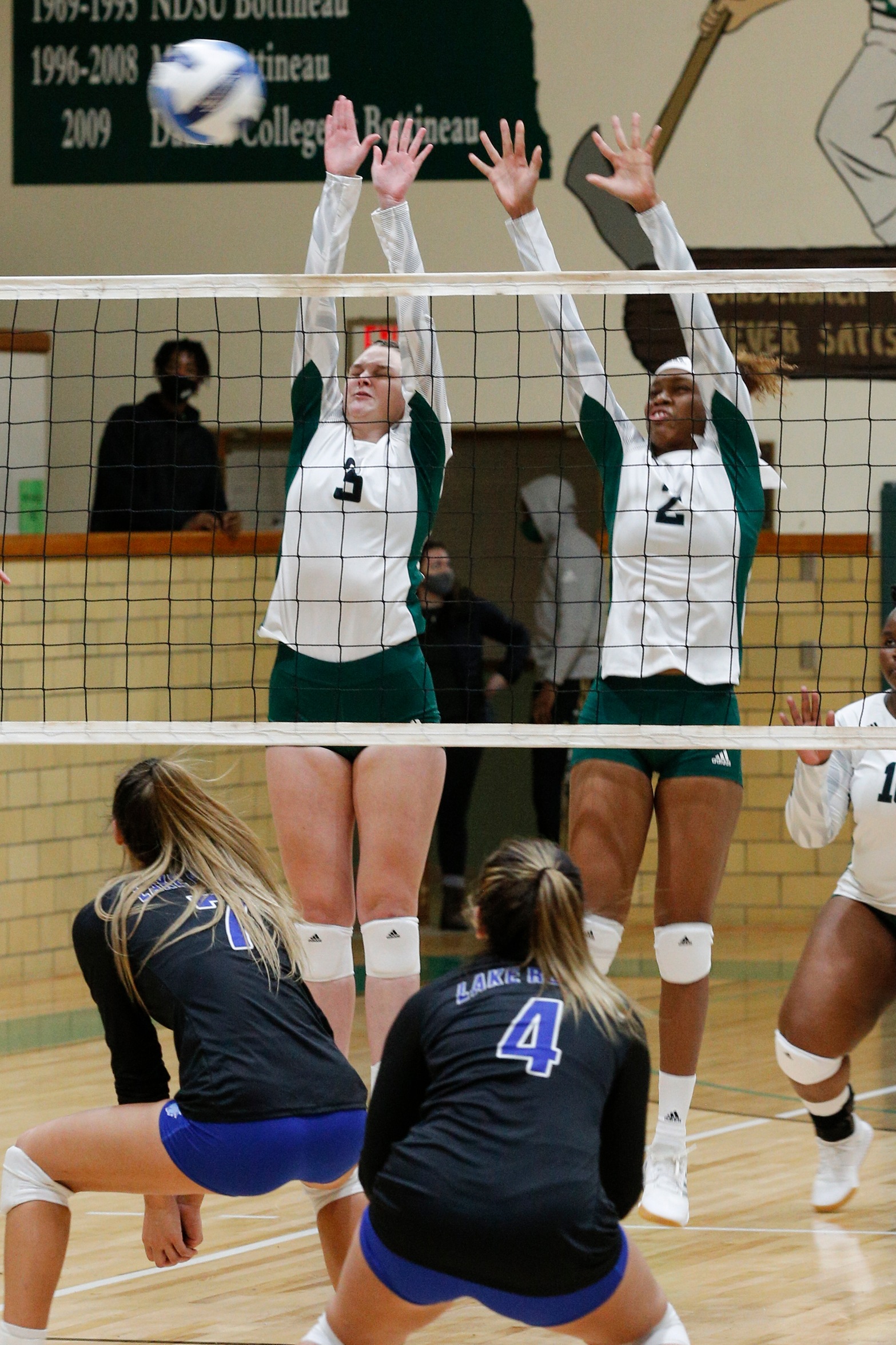 Sophomore Rebekka Bummer (3) and Freshman Chante Moore (2) go up to block a Lake Region attack last night in the Woodshed.